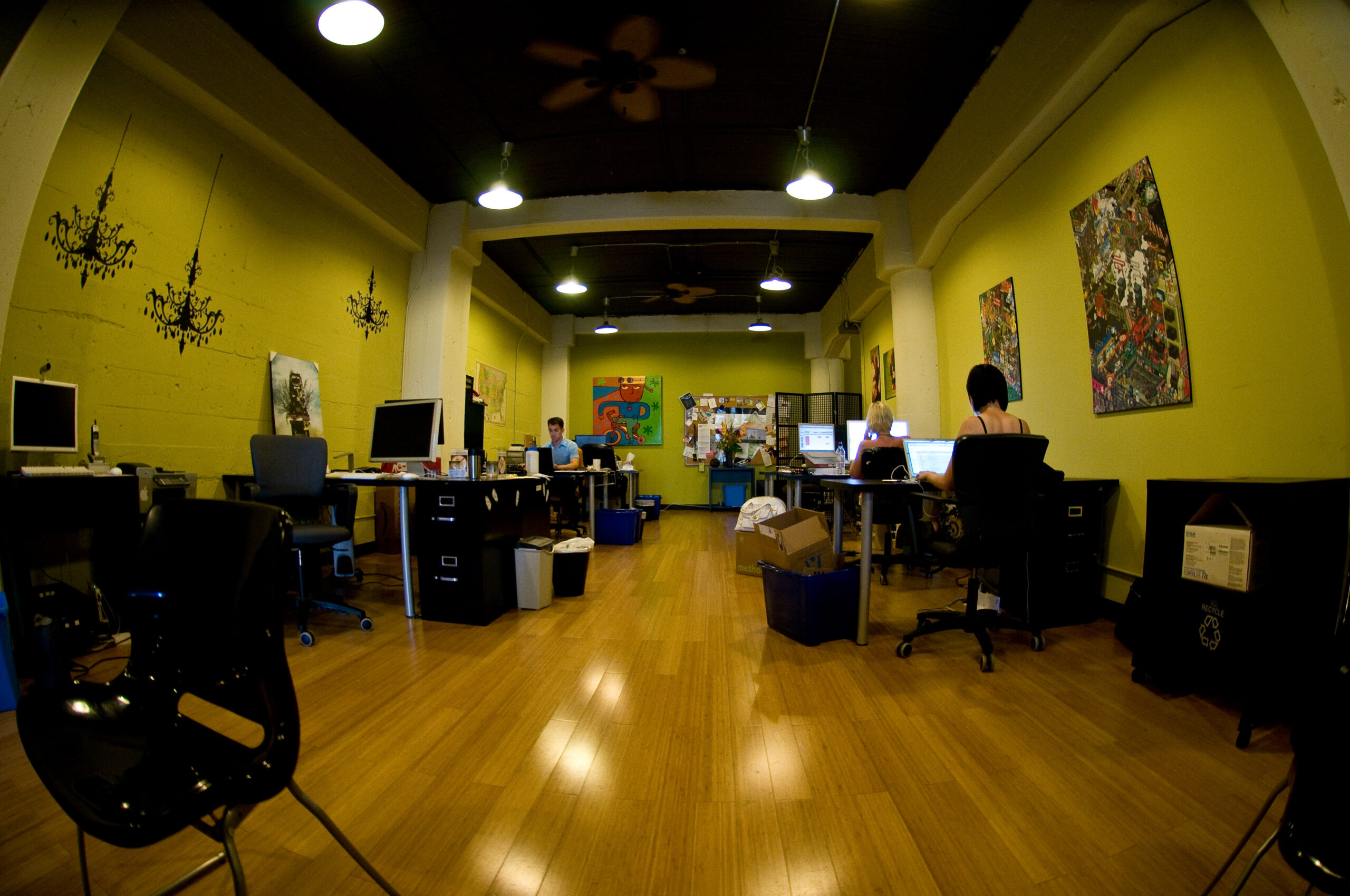 Desks and laptops in a shared workspace.