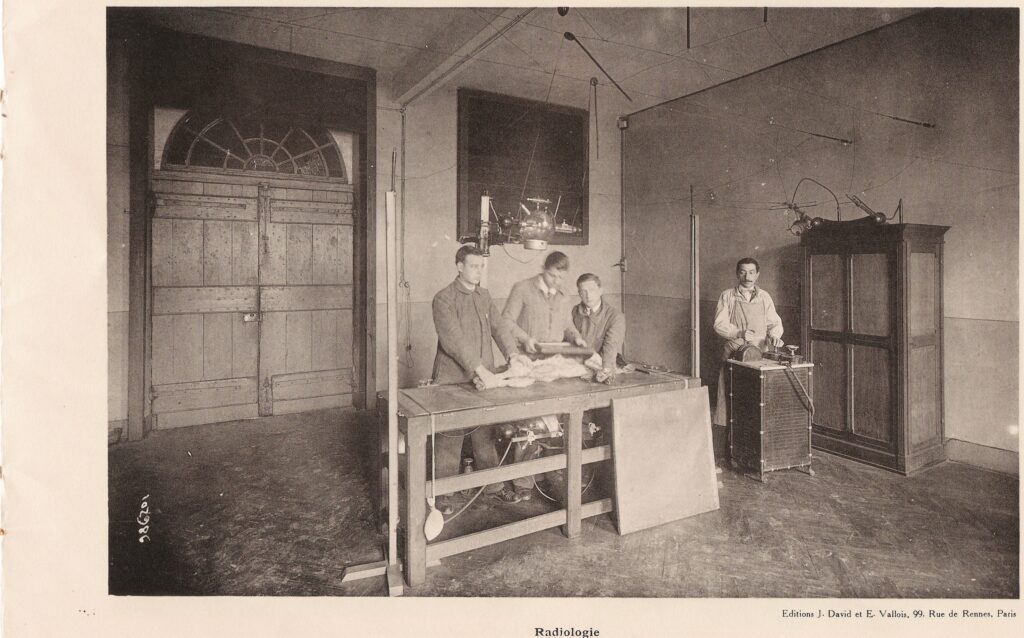 A radiology room with an imaging table and control area