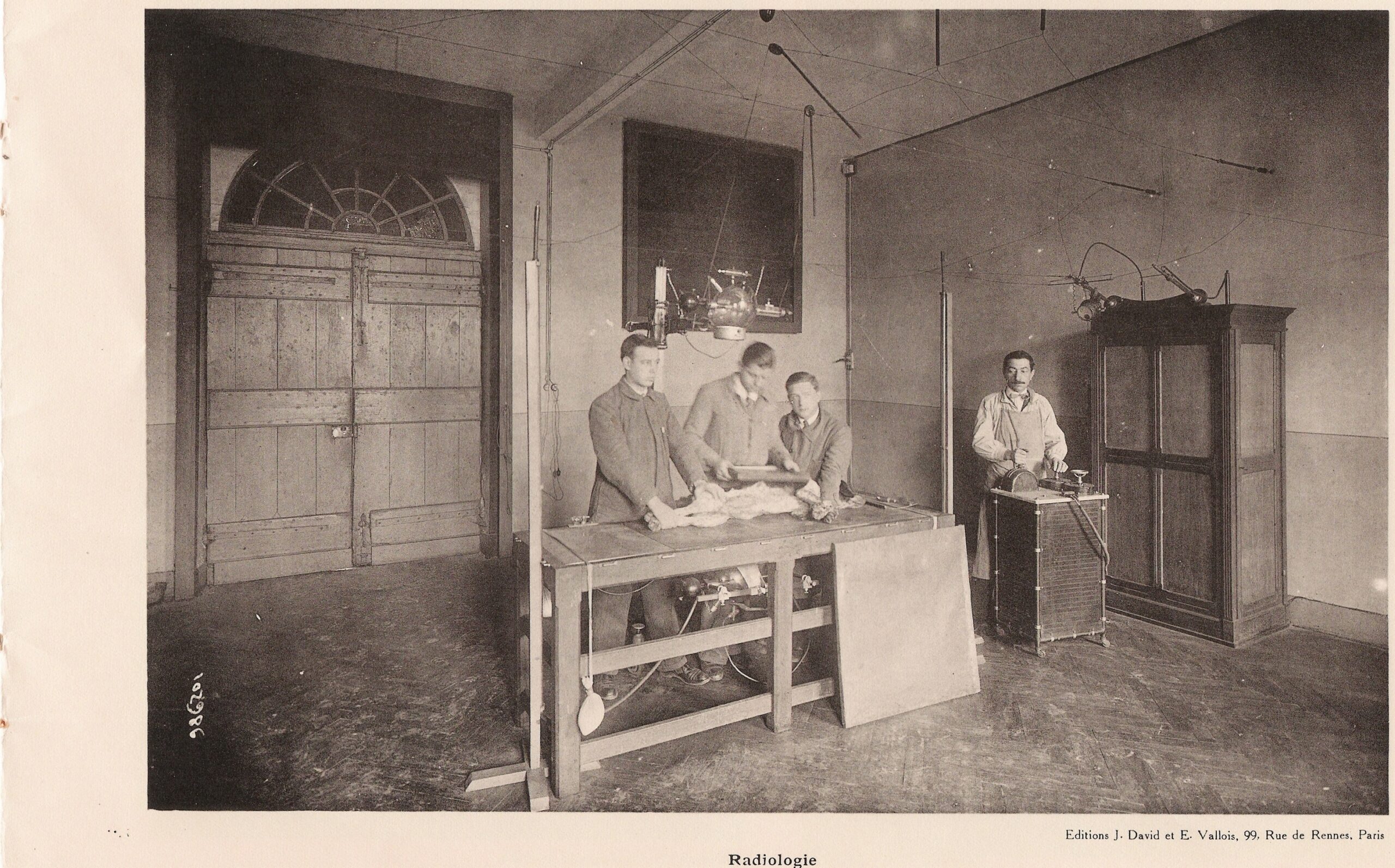 A radiology room with an imaging table and control area