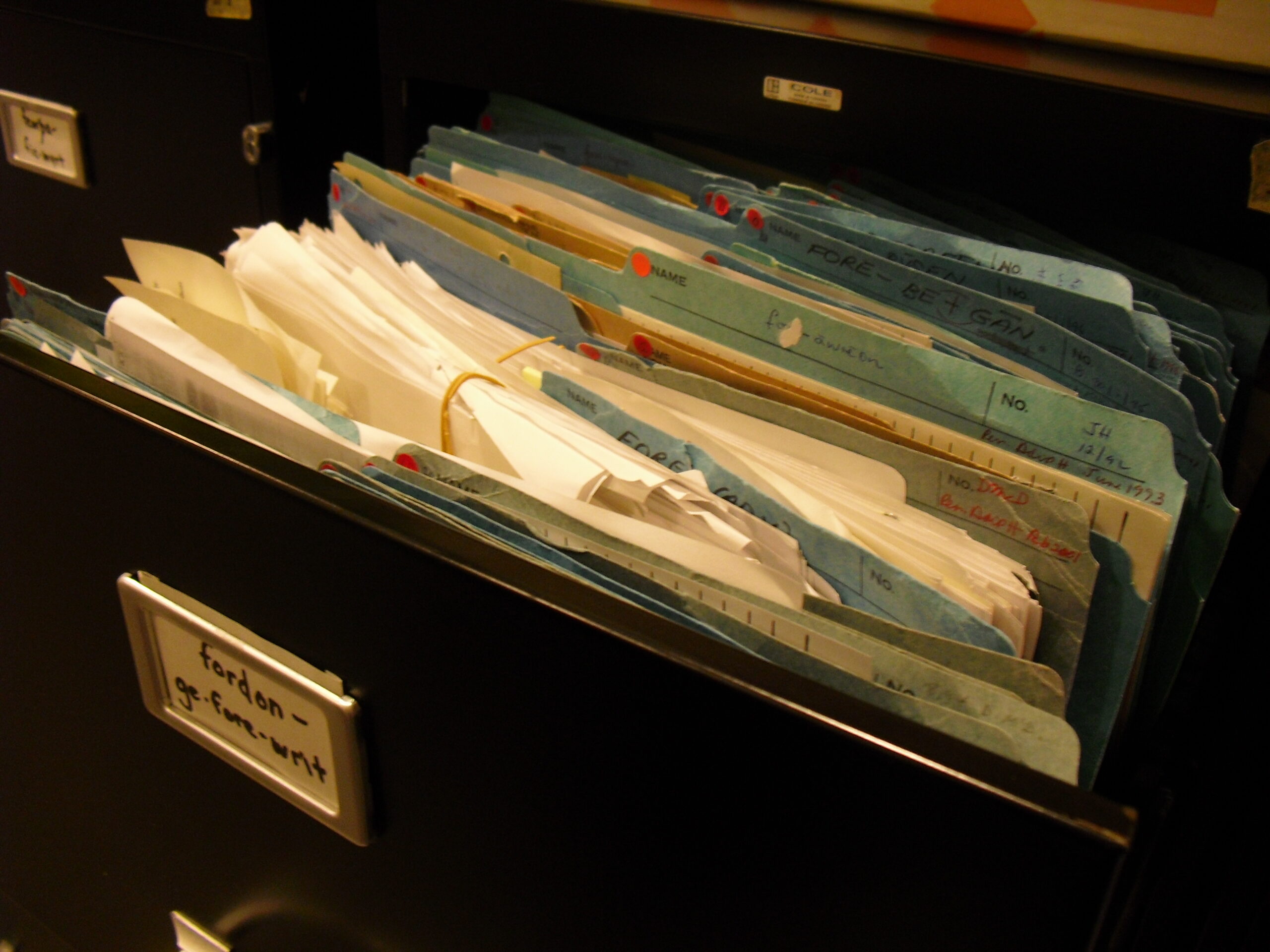 Archived paper research files in storage boxes