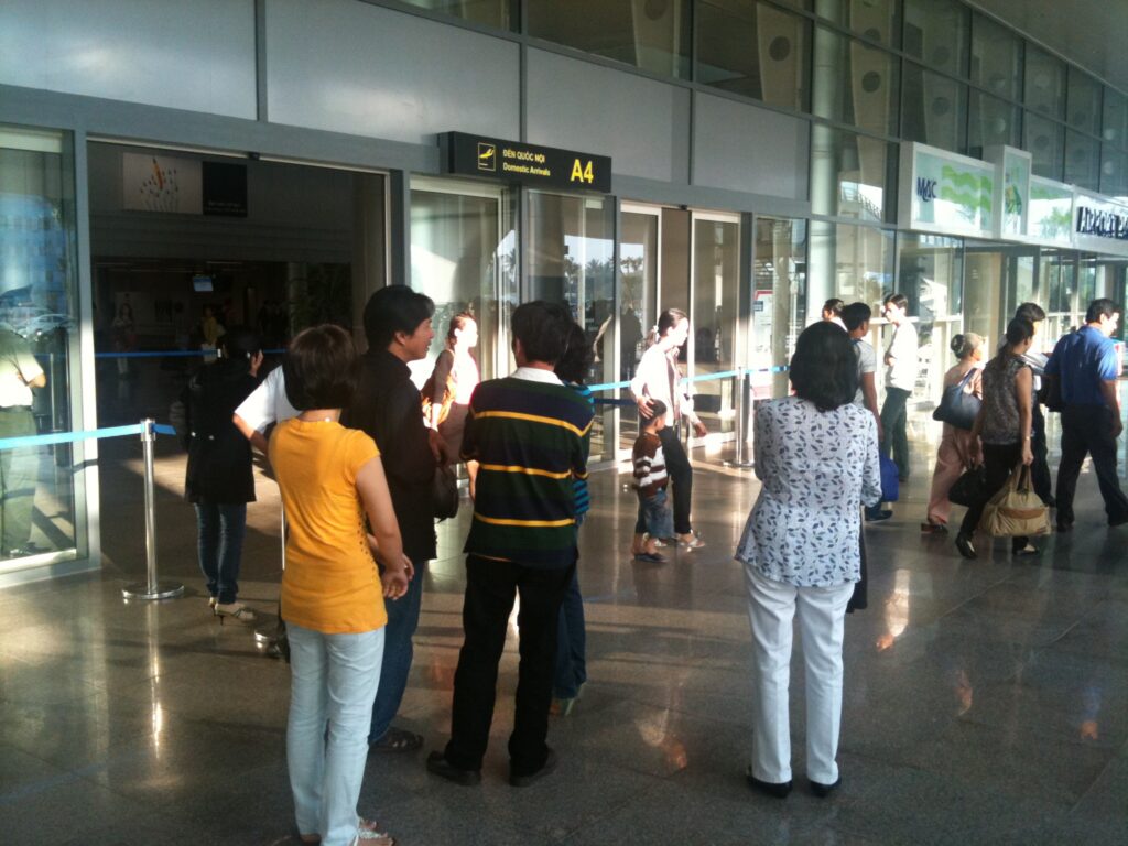 People waiting at the arrivals hall of an international airport terminal