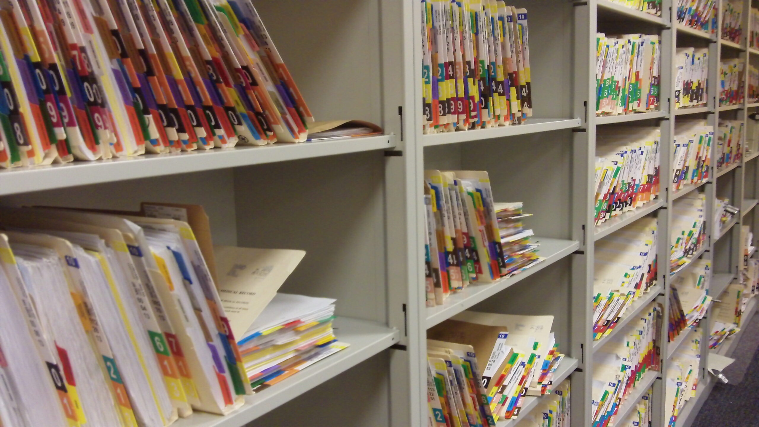 Shelves of paper patient files in a hospital records room